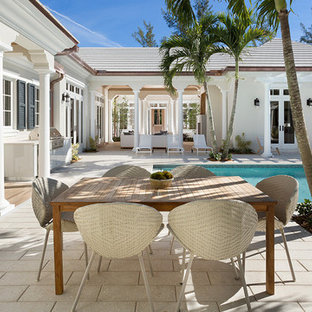 Esempio di un patio o portico tropicale di medie dimensioni e dietro casa con cemento stampato e un tetto a sbalzo