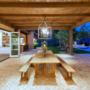 Patio kitchen - mediterranean backyard brick patio kitchen idea in Phoenix with an awning