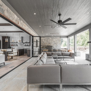 Idee per un patio o portico design dietro casa con un tetto a sbalzo e un caminetto