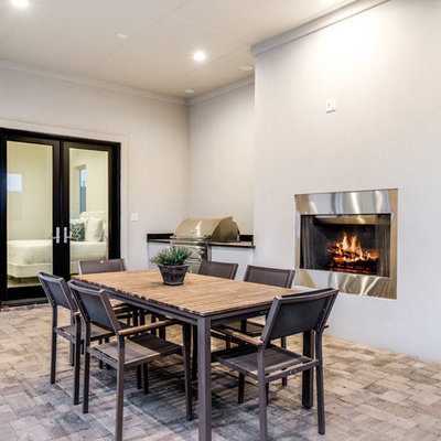Inspiration for a transitional backyard brick patio kitchen remodel in Dallas with a roof extension