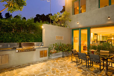 Example of a trendy backyard stone patio kitchen design in Los Angeles with no cover