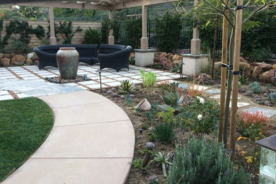 Ejemplo de patio contemporáneo pequeño en patio trasero con fuente, adoquines de piedra natural y pérgola