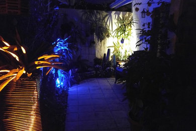 Diseño de patio ecléctico pequeño en patio con jardín de macetas, suelo de hormigón estampado y toldo
