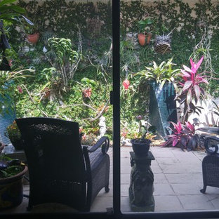 Foto di un piccolo patio o portico boho chic in cortile con cemento stampato e un parasole