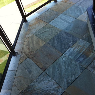 Esempio di un piccolo patio o portico scandinavo dietro casa con un focolare, pavimentazioni in pietra naturale e un tetto a sbalzo