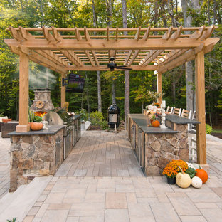 Esempio di un grande patio o portico tradizionale dietro casa con pavimentazioni in cemento e una pergola