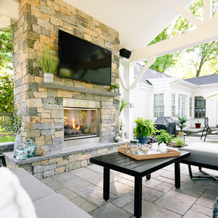Ispirazione per un grande patio o portico chic dietro casa con un caminetto, pavimentazioni in cemento e un gazebo o capanno