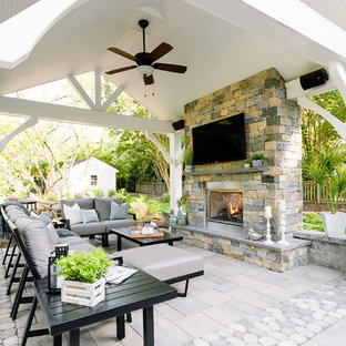 Ispirazione per un grande patio o portico tradizionale dietro casa con un caminetto, pavimentazioni in cemento e un gazebo o capanno