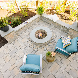 Esempio di un patio o portico tradizionale di medie dimensioni e dietro casa con un focolare, pavimentazioni in cemento e una pergola