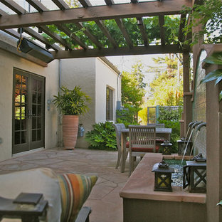 Idee per un piccolo patio o portico stile americano dietro casa con pavimentazioni in pietra naturale e fontane