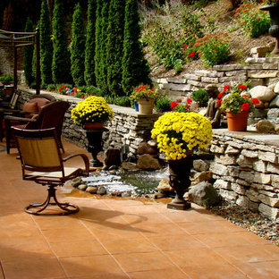 Ispirazione per un grande patio o portico eclettico dietro casa con fontane, cemento stampato e un gazebo o capanno