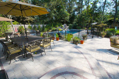 Inspiration for a timeless backyard concrete paver patio kitchen remodel in New York