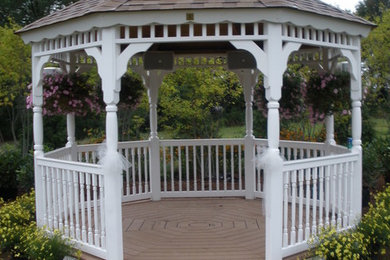 Example of a mid-sized classic backyard brick patio design in New York with a gazebo