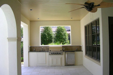 タンパにある高級な中くらいなトランジショナルスタイルのおしゃれな裏庭のテラス (アウトドアキッチン、レンガ敷き、張り出し屋根) の写真