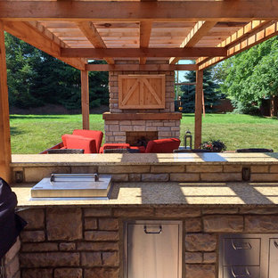 Idee per un grande patio o portico country dietro casa con un focolare, pavimentazioni in cemento e una pergola