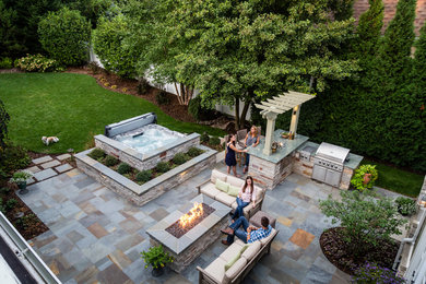 Diseño de patio clásico renovado extra grande sin cubierta en patio trasero con cocina exterior y adoquines de piedra natural