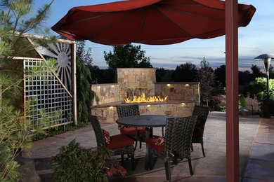 Inspiration for a mid-sized backyard concrete paver patio remodel in Boise with a fire pit and a roof extension