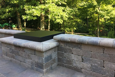 Example of a mid-sized classic backyard concrete paver patio design in Other with a fire pit and no cover