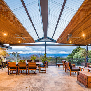 Ispirazione per un grande patio o portico design con piastrelle e una pergola