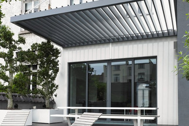 Patio - mid-sized contemporary patio idea in New York with a pergola