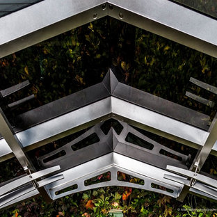 Immagine di un patio o portico minimal di medie dimensioni e dietro casa con piastrelle e un gazebo o capanno