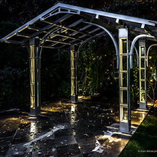 Idee per un patio o portico minimal di medie dimensioni e dietro casa con piastrelle e un gazebo o capanno