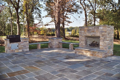Large backyard stone patio photo in Baltimore with a fire pit and no cover