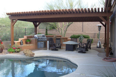 Large elegant backyard concrete patio kitchen photo in Phoenix with a pergola
