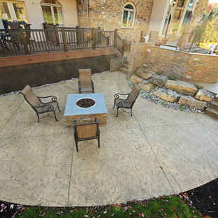 Ispirazione per un grande patio o portico chic davanti casa con un focolare e cemento stampato