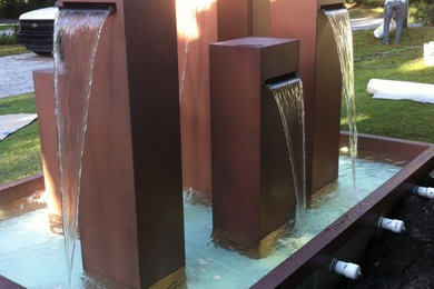 Example of a mid-sized minimalist front yard patio fountain design in Miami with no cover