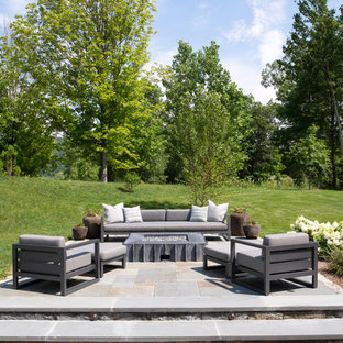 Foto di un patio o portico country dietro casa e di medie dimensioni con un focolare e nessuna copertura