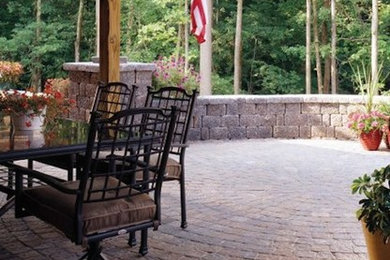 Inspiration for a mid-sized timeless backyard brick patio remodel in New York with a roof extension