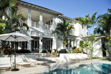 マイアミにあるラグジュアリーな巨大なビーチスタイルのおしゃれな裏庭のテラス (天然石敷き、張り出し屋根) の写真