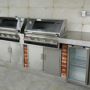 Ispirazione per un patio o portico shabby-chic style in cortile con piastrelle e un tetto a sbalzo