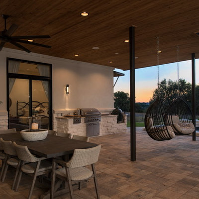 Inspiration for a contemporary backyard patio kitchen remodel in Austin with a roof extension