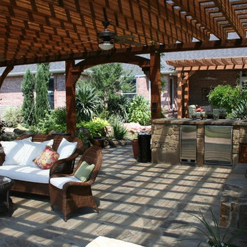 Arbor, outdoor kitchen, fireplace.