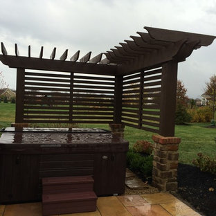 Foto di un piccolo patio o portico minimal dietro casa con pavimentazioni in pietra naturale e una pergola