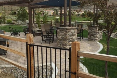 Example of a mid-sized tuscan backyard brick patio design in Other with a pergola