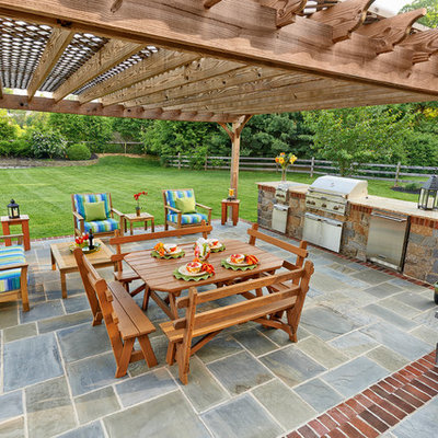 Example of a classic stone patio kitchen design in Wilmington with a gazebo