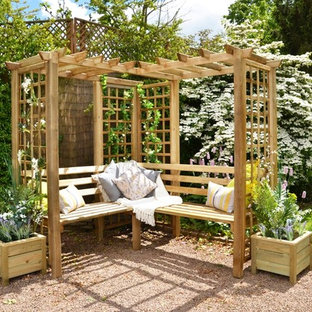 Foto di un patio o portico tradizionale dietro casa con ghiaia e una pergola