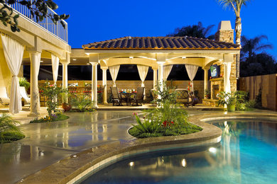 Großer Mediterraner Patio hinter dem Haus mit Outdoor-Küche, Betonplatten und Gazebo in Los Angeles