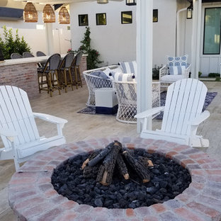 Foto di un patio o portico country di medie dimensioni e dietro casa con piastrelle e una pergola