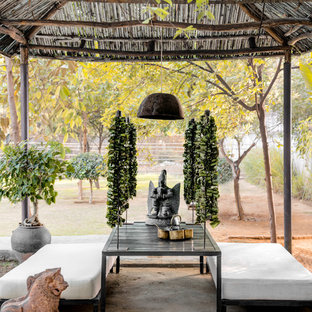 Ispirazione per un patio o portico etnico dietro casa con un gazebo o capanno