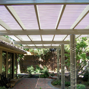 Idee per un patio o portico stile americano di medie dimensioni e dietro casa con lastre di cemento e una pergola
