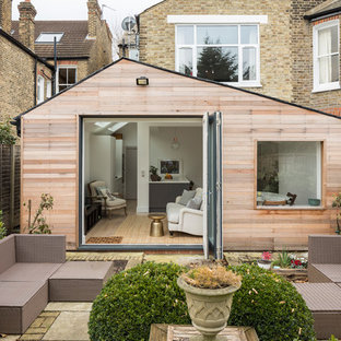 Photo of a contemporary back patio in London with natural stone paving and no cover.