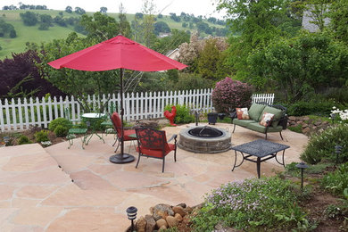 サクラメントにあるお手頃価格の広いトラディショナルスタイルのおしゃれな裏庭のテラス (ファイヤーピット、天然石敷き、日よけなし) の写真