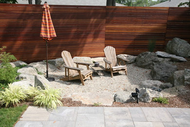 Foto de patio moderno de tamaño medio en patio trasero con brasero y gravilla