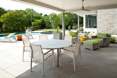 Large minimalist backyard concrete paver patio photo in Dallas