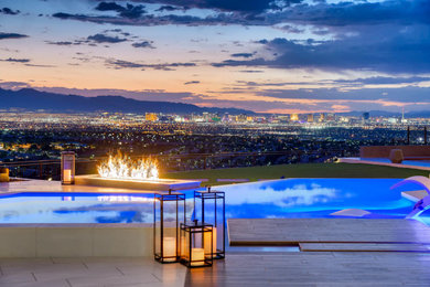 Huge trendy backyard stone patio photo in Las Vegas with a fire pit and a roof extension