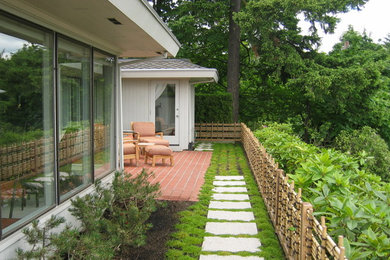 Idée de décoration pour une terrasse arrière asiatique de taille moyenne avec des pavés en brique.
